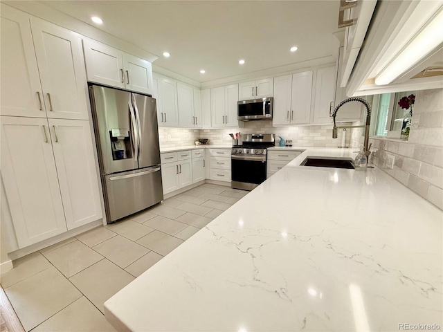 4425 E Harvard Ave, Denver, CO 80222 - kitchen featuring stainless steel appliances, a sink, decorative backsplash, white cabinets, and recessed lighting