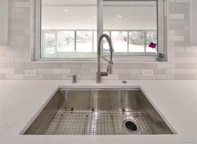 4425 E Harvard Ave, Denver, CO 80222 - kitchen view of a sink, tasteful backsplash, and light stone counters