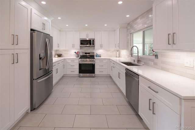 4425 E Harvard Ave, Denver, CO 80222 - kitchen with appliances with stainless steel finishes, a sink, tasteful backsplash, white cabinets, and light countertops