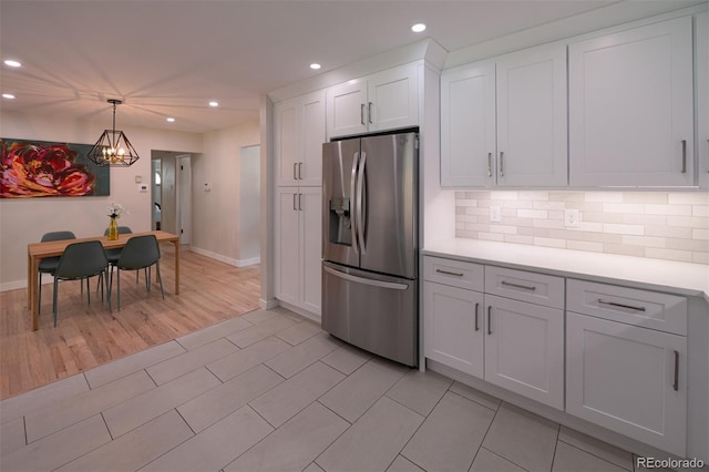 4425 E Harvard Ave, Denver, CO 80222 - kitchen with stainless steel fridge, recessed lighting, light countertops, white cabinetry, and baseboards