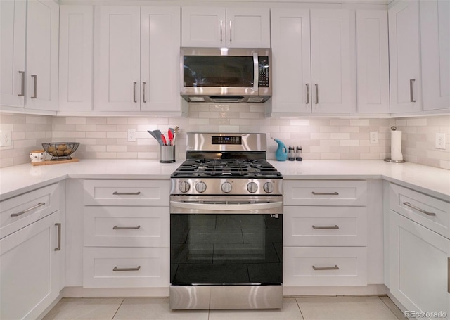 4425 E Harvard Ave, Denver, CO 80222 - kitchen with appliances with stainless steel finishes, white cabinetry, light countertops, and light tile patterned floors