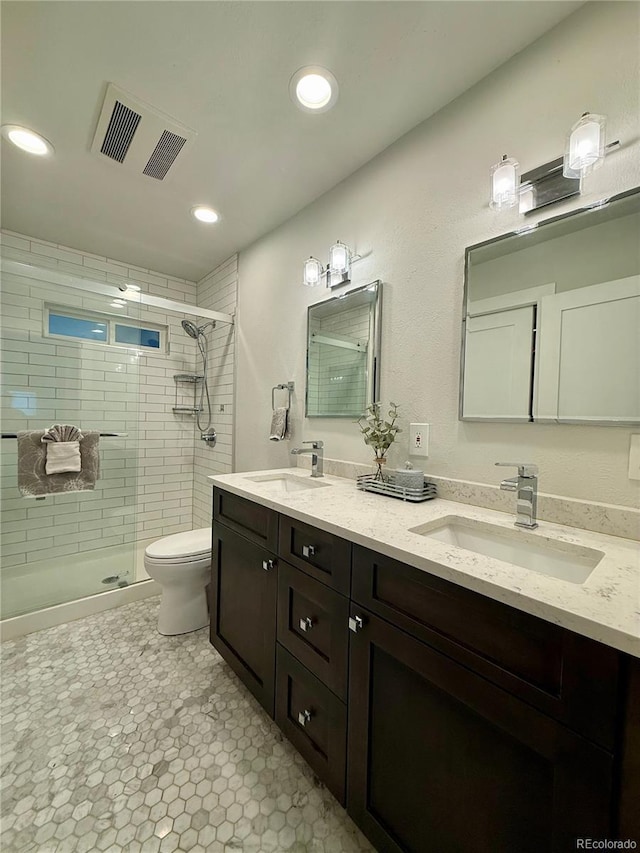 4425 E Harvard Ave, Denver, CO 80222 - bathroom featuring a shower stall, toilet, double vanity, and recessed lighting