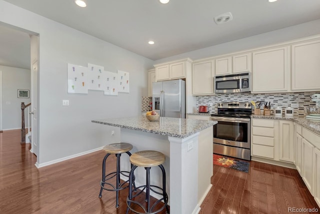 7686 Grady Cir, Castle Rock, CO 80108 - kitchen featuring stainless steel appliances, light stone countertops, backsplash, a center island, and recessed lighting
