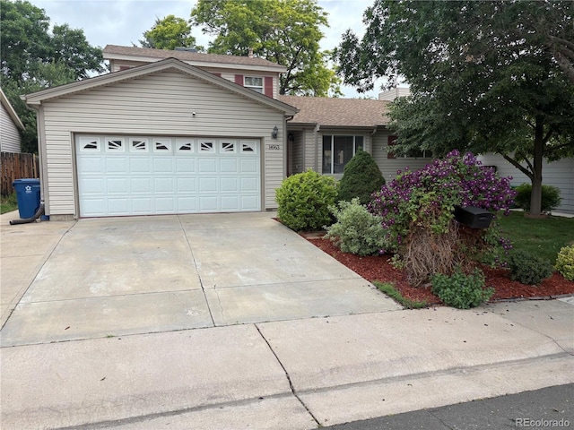 14963 E Adriatic Pl, Aurora, CO 80014 - traditional-style house with a garage, driveway, roof with shingles, and a chimney