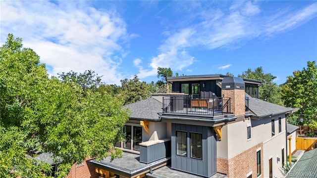 rear view of property featuring a balcony