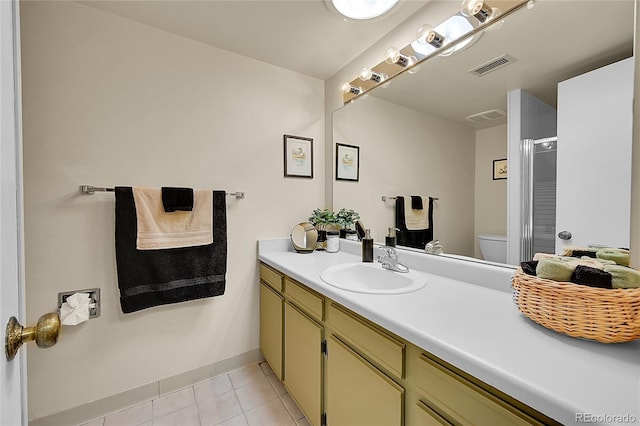 bathroom featuring tile patterned floors, toilet, a shower with shower door, and vanity