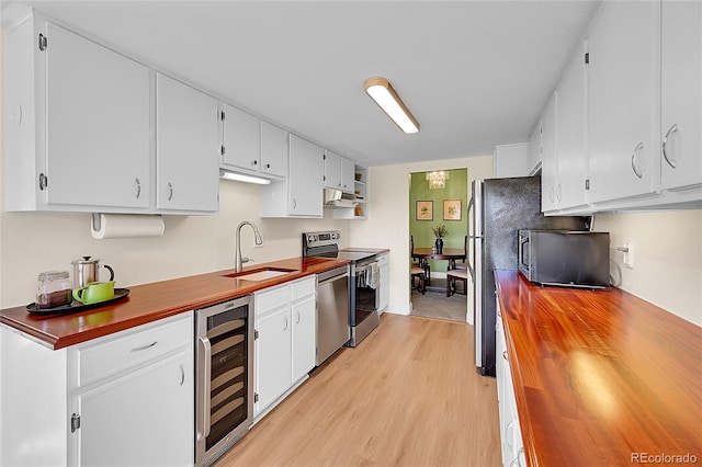 kitchen featuring wine cooler, white cabinetry, appliances with stainless steel finishes, and butcher block counters