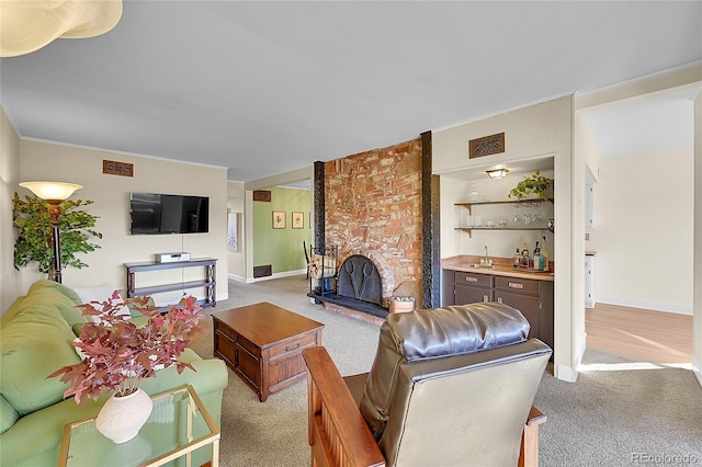 carpeted living room featuring bar area and a brick fireplace