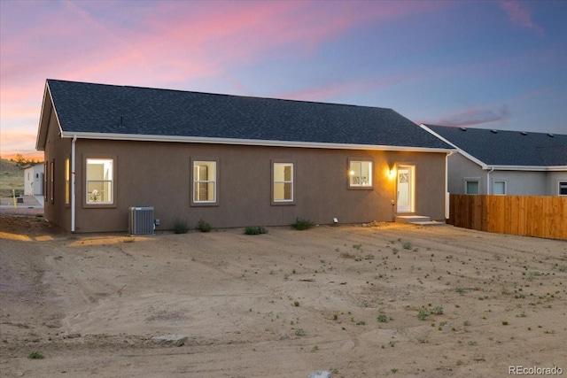 back house at dusk with central air condition unit