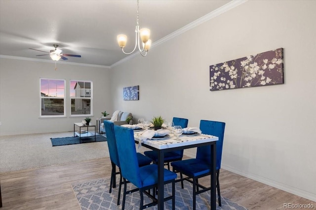 dining area featuring ceiling fan with notable chandelier, ornamental molding, and hardwood / wood-style floors