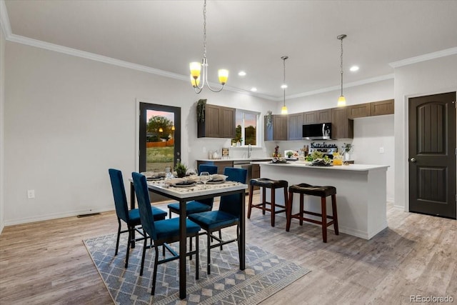 dining space featuring crown molding and light hardwood / wood-style flooring