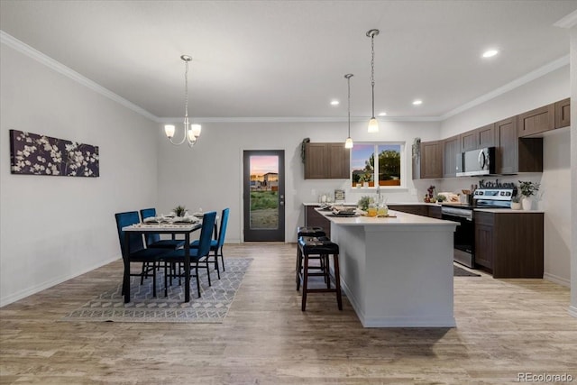 kitchen with light hardwood / wood-style floors, decorative light fixtures, stainless steel range with electric cooktop, and a center island