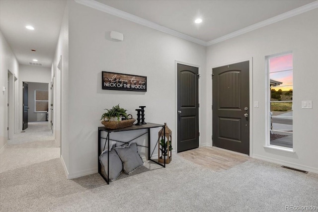 entryway featuring crown molding and light colored carpet