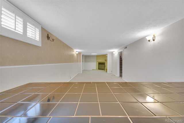 8841 Hunter Way, Westminster, CO 80031 - unfurnished room with a tile fireplace, a textured ceiling, and carpet