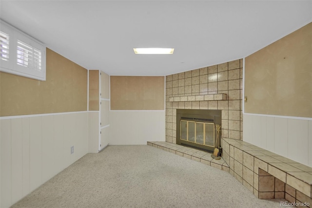 8841 Hunter Way, Westminster, CO 80031 - unfurnished living room featuring a tiled fireplace, carpet floors, and a wainscoted wall