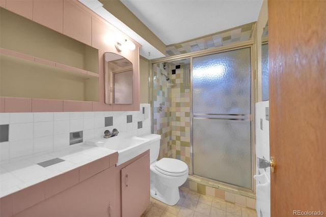8841 Hunter Way, Westminster, CO 80031 - bathroom featuring vanity, a shower stall, tile walls, and tasteful backsplash