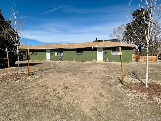 rear view of property with fence and brick siding