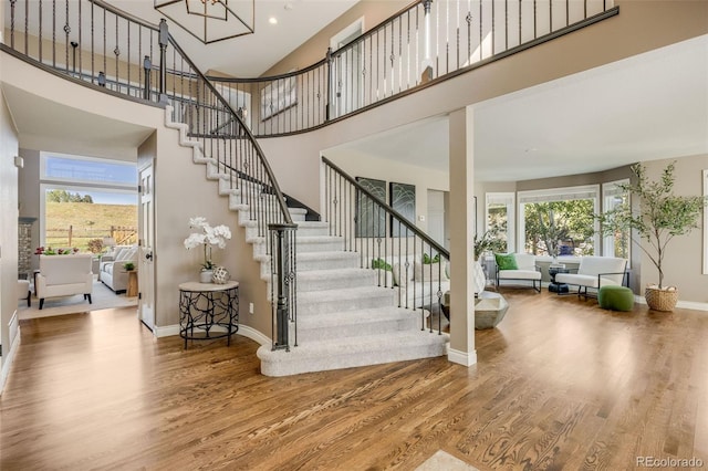 7067 Gray Fox Ct, Highlands Ranch, CO 80130 - stairway featuring wood finished floors, baseboards, a towering ceiling, and recessed lighting