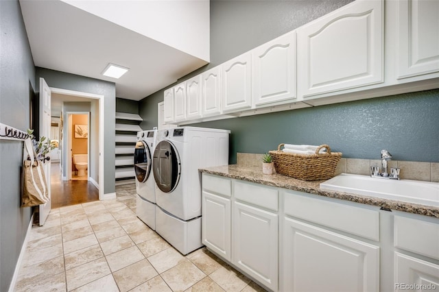 7067 Gray Fox Ct, Highlands Ranch, CO 80130 - laundry area featuring washing machine and clothes dryer, cabinet space, and a textured wall