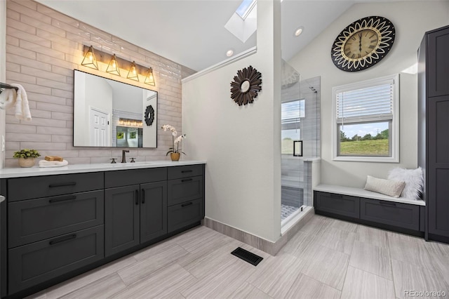 7067 Gray Fox Ct, Highlands Ranch, CO 80130 - bathroom featuring lofted ceiling, vanity, a shower stall, a skylight, and tasteful backsplash