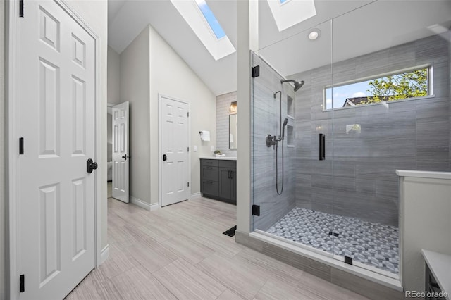 7067 Gray Fox Ct, Highlands Ranch, CO 80130 - full bathroom with a skylight, vanity, a shower stall, vaulted ceiling, and baseboards