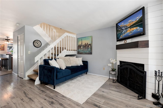 9713 W Chatfield Ave Unit F, Littleton, CO 80128 - living room featuring wood finished floors, stairs, baseboards, a large fireplace, and a ceiling fan