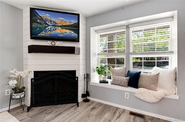 9713 W Chatfield Ave Unit F, Littleton, CO 80128 - sitting room with wood finished floors, baseboards, and a large fireplace