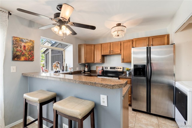 9713 W Chatfield Ave Unit F, Littleton, CO 80128 - kitchen with stainless steel appliances, a kitchen bar, a ceiling fan, a peninsula, and light tile patterned floors
