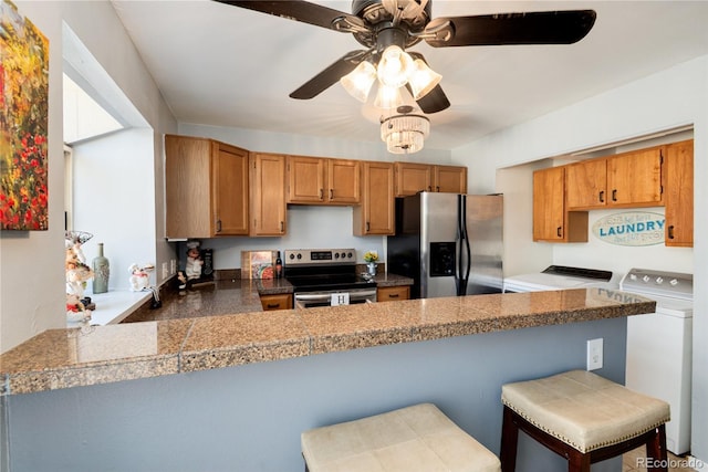 9713 W Chatfield Ave Unit F, Littleton, CO 80128 - kitchen featuring appliances with stainless steel finishes, tile counters, ceiling fan, and brown cabinets