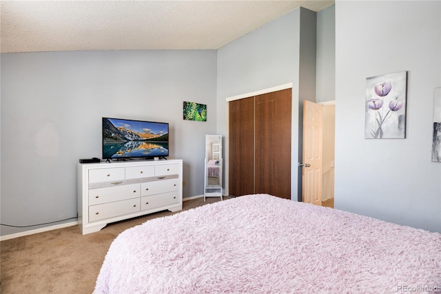 9713 W Chatfield Ave Unit F, Littleton, CO 80128 - bedroom featuring carpet floors, a closet, vaulted ceiling, and baseboards