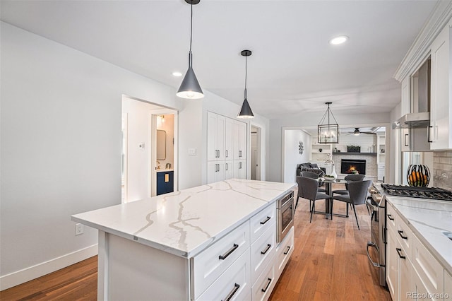 kitchen featuring white cabinetry, appliances with stainless steel finishes, a kitchen island, and pendant lighting