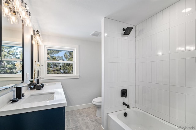 full bathroom with vanity, hardwood / wood-style flooring, toilet, and tiled shower / bath