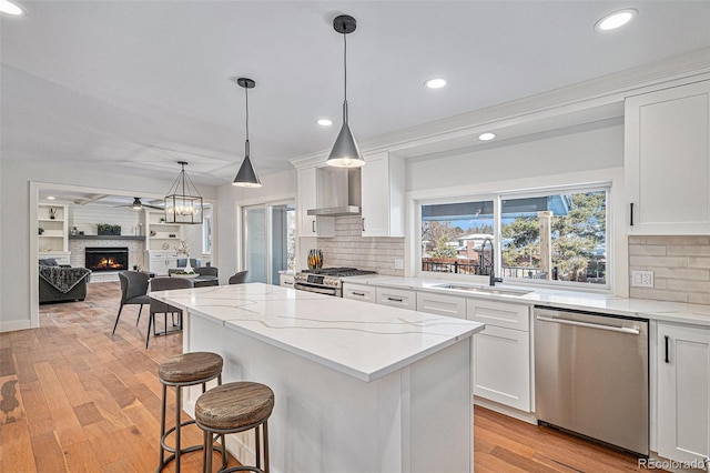 kitchen with light stone counters, sink, stainless steel appliances, and white cabinets