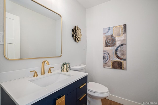 bathroom featuring vanity, wood-type flooring, and toilet