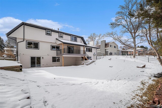 view of snow covered back of property