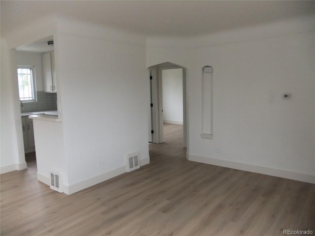 3243 Albion St, Denver, CO 80207 - unfurnished room with light wood-type flooring and arched walkways