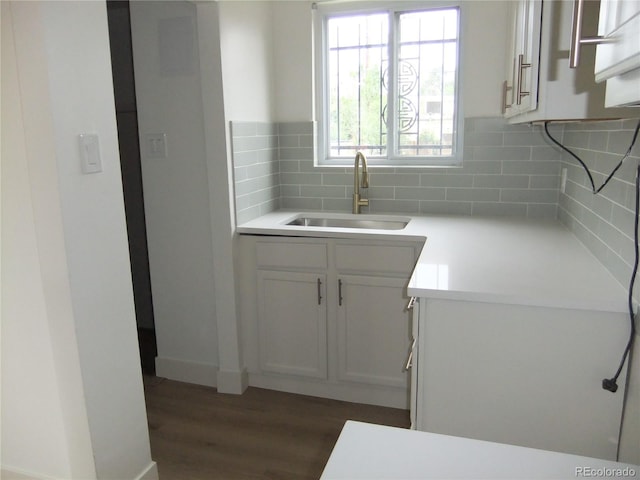 3243 Albion St, Denver, CO 80207 - kitchen featuring backsplash, dark wood-type flooring, light countertops, and white cabinetry