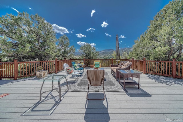 wooden terrace with outdoor lounge area and a mountain view