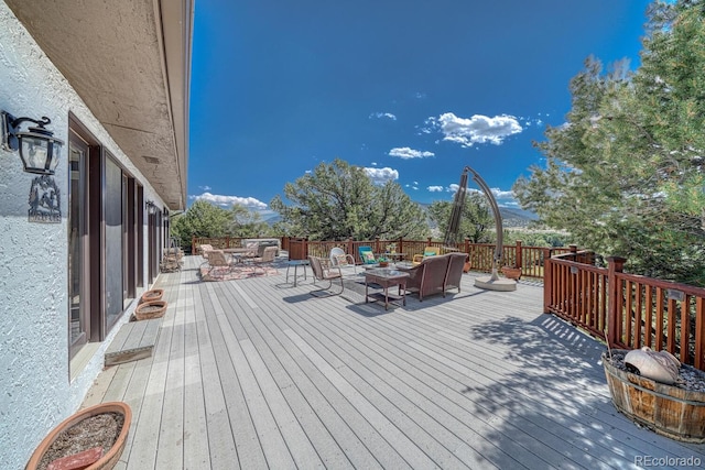 wooden terrace with a mountain view and an outdoor living space