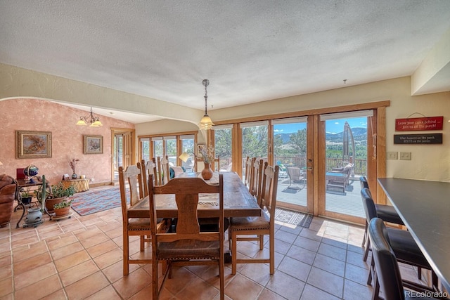 dining room with tile patterned flooring, an inviting chandelier, a textured ceiling, and french doors