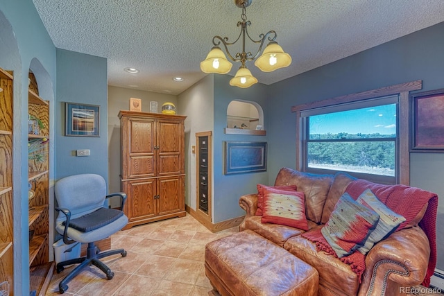 office space with a textured ceiling, a notable chandelier, and light tile patterned flooring