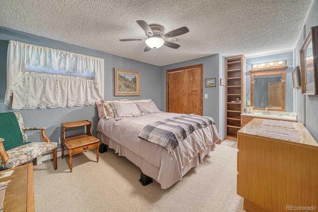 carpeted bedroom with baseboard heating, ceiling fan, and a textured ceiling