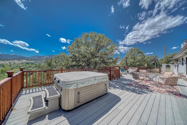 wooden deck featuring a mountain view and a hot tub