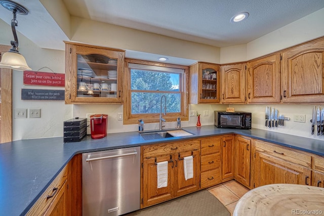 kitchen with a textured ceiling, sink, pendant lighting, light tile patterned floors, and dishwasher