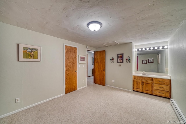 unfurnished bedroom with ensuite bath, light carpet, sink, and a baseboard radiator