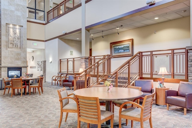 13606 E Bates Ave Unit 102, Aurora, CO 80014 - dining area with a towering ceiling, stairway, and a fireplace