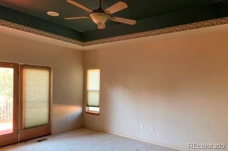 carpeted spare room featuring ceiling fan