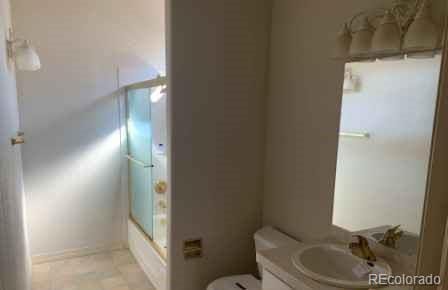 full bathroom featuring toilet, vanity, and combined bath / shower with glass door