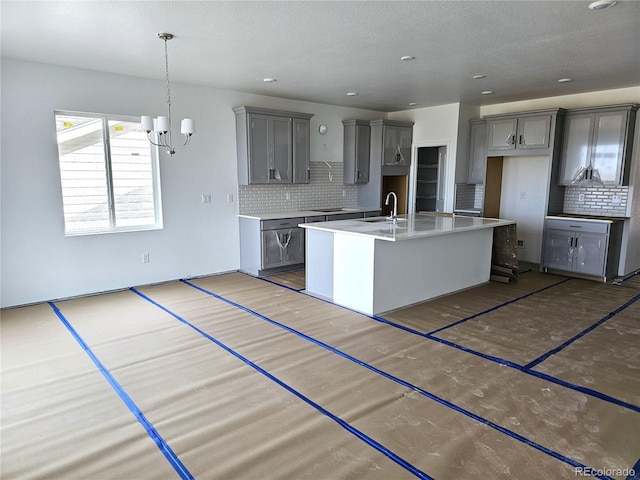 kitchen featuring a sink, decorative backsplash, and gray cabinets