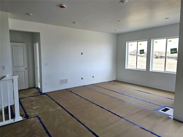 unfurnished room with visible vents